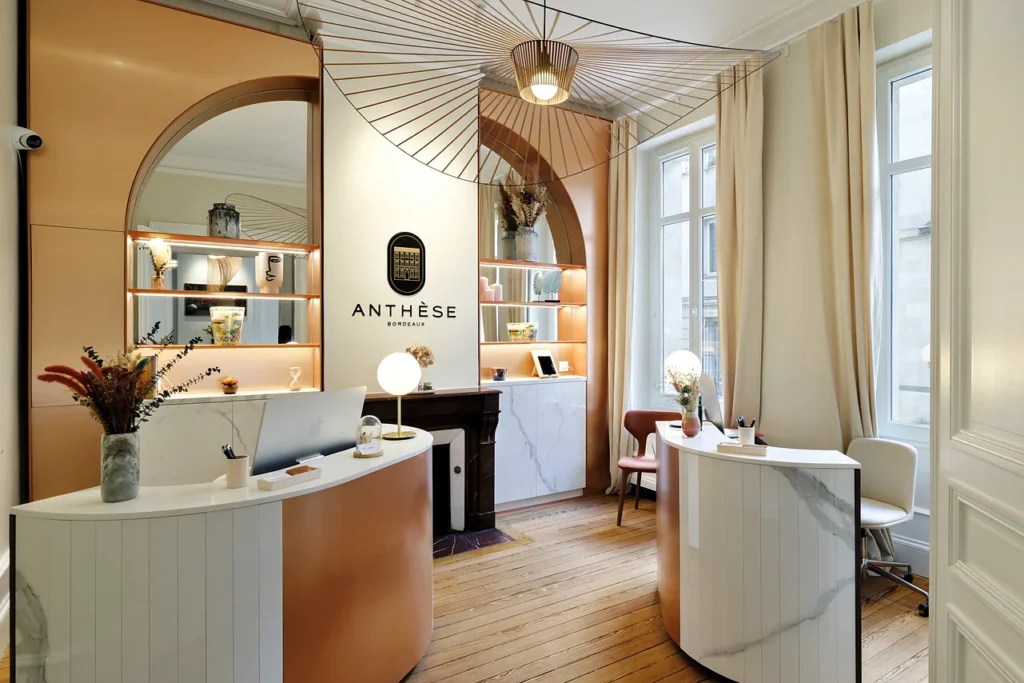 Reception at Clinique Anthèse in Bordeaux, with curved desks and wall signage.