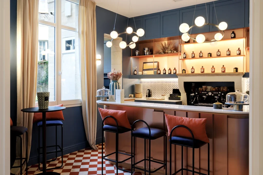 Counter at Clinique Anthèse in Bordeaux, with high stools and illuminated shelving.
