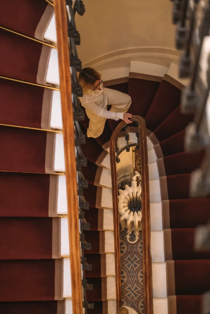 Overhead view of the interior staircase at Clinique Anthèse in Bordeaux, with a person moving between floors.