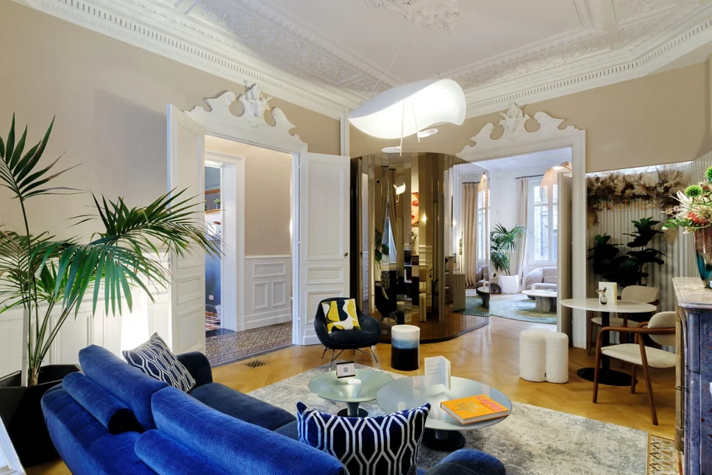 Lounge area at Clinique Anthèse in Bordeaux, with blue sofa and circulation towards adjoining rooms.