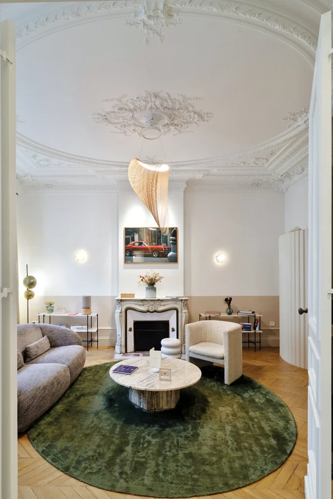 Salon at Clinique Anthèse in Bordeaux, with fireplace, furniture and green rug.